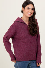 woman wearing a burgundy oversized sweater with a zip-up collar and long sleeves
