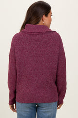 woman wearing a burgundy oversized maternity sweater with a high collar, viewed from the back
