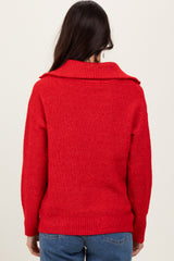 woman wearing a vibrant red chunky knit sweater with a wide collar, viewed from the back