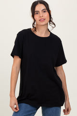woman wearing a relaxed fit black t-shirt with short sleeves and a round neckline, paired with denim jeans