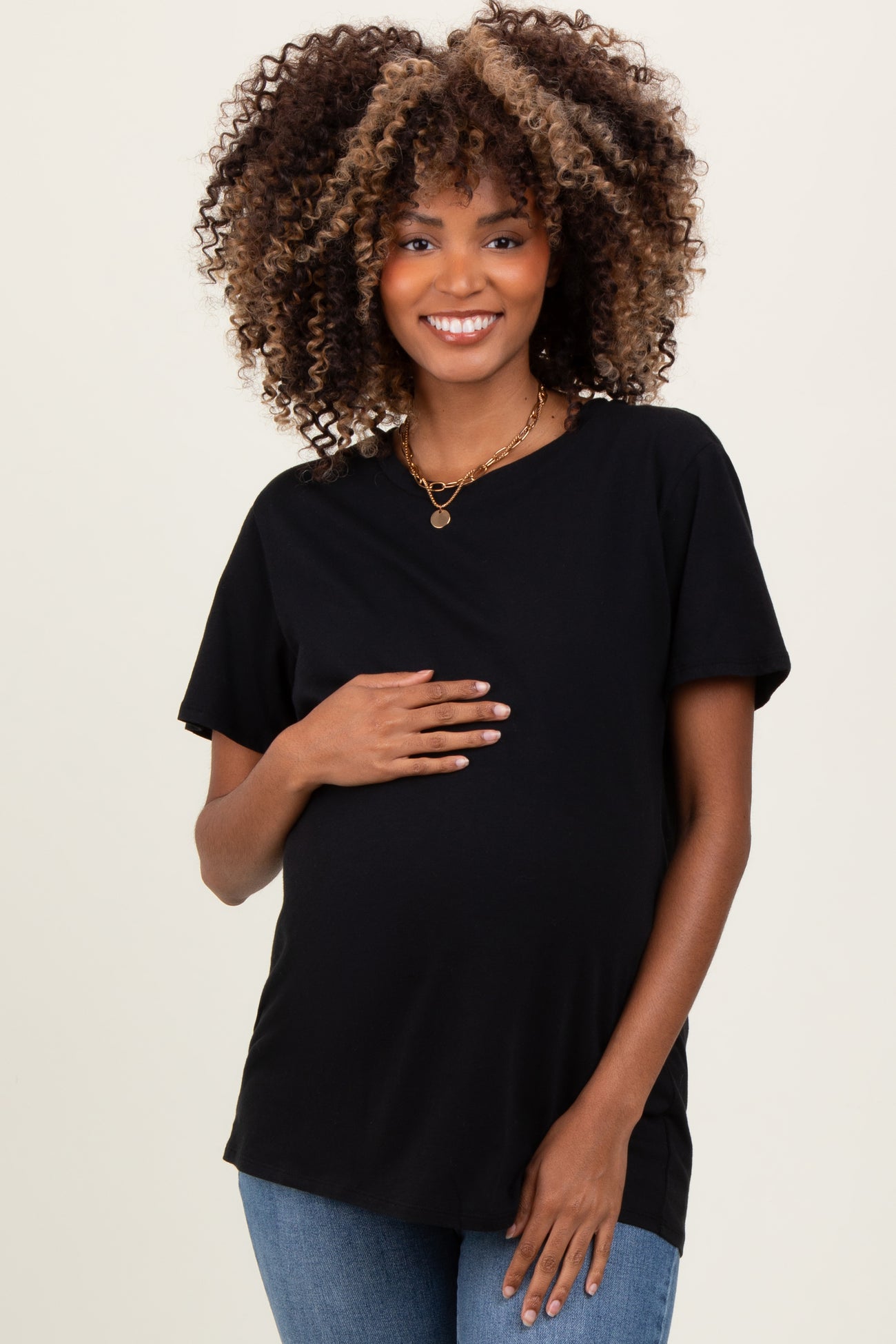 woman wearing a black short sleeve maternity top and showing her baby bump