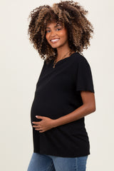 woman wearing a black short sleeve maternity top and holding her baby bump