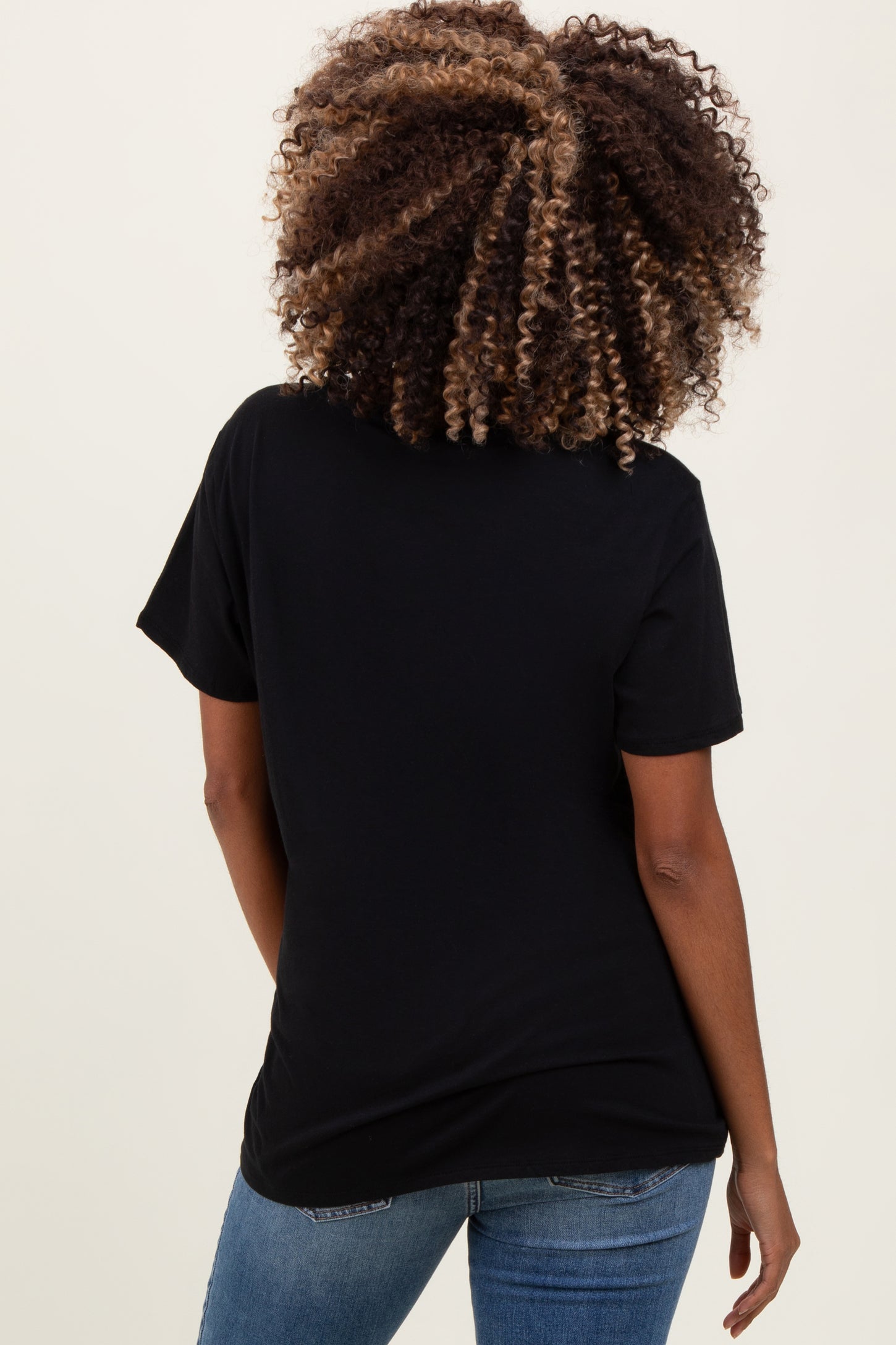 woman wearing a black short sleeve maternity top, view from the back, paired with blue jeans