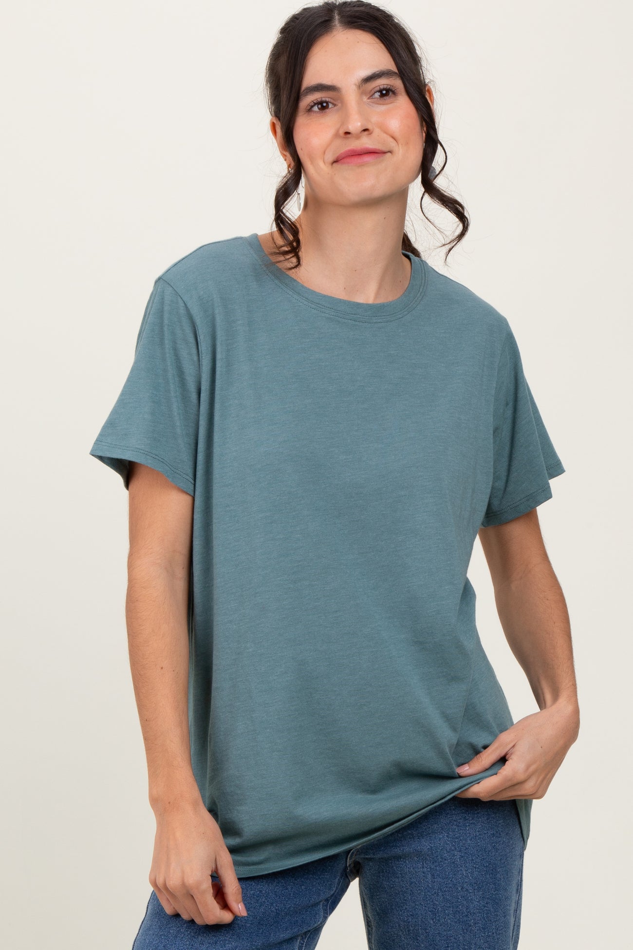 woman wearing a teal short sleeve t-shirt with a relaxed fit and jeans