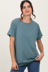 woman wearing a teal short sleeve t-shirt with a relaxed fit and jeans