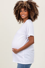 woman wearing a white short sleeve maternity top and showing her baby bump