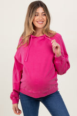 woman wearing a pink maternity hoodie with a relaxed fit and a baby bump visible