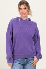 woman wearing a purple oversized hoodie with a drawstring and relaxed fit, paired with light blue jeans