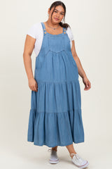 woman wearing a blue denim maxi dress with tiered ruffles over a white t-shirt and white sneakers