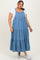 woman wearing a blue denim maxi dress with tiered ruffles over a white t-shirt and white sneakers
