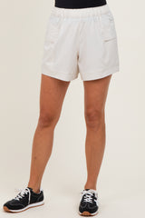woman wearing white athletic shorts with an elastic waistband and front pockets