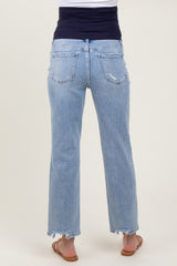woman wearing light blue maternity jeans with a distressed hem and a fitted black top, showing a baby bump from the back