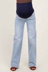 woman wearing light blue maternity jeans with a navy blue supportive waistband and tan sandals