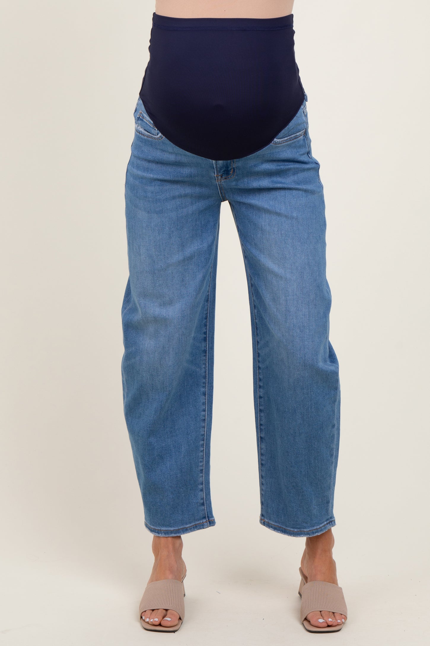maternity wear dark blue high-waisted jeans with a stretchy belly panel, styled with a relaxed fit