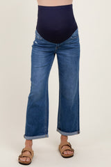 woman wearing a navy blue maternity belly band with wide leg denim jeans, casual style with rolled cuffs