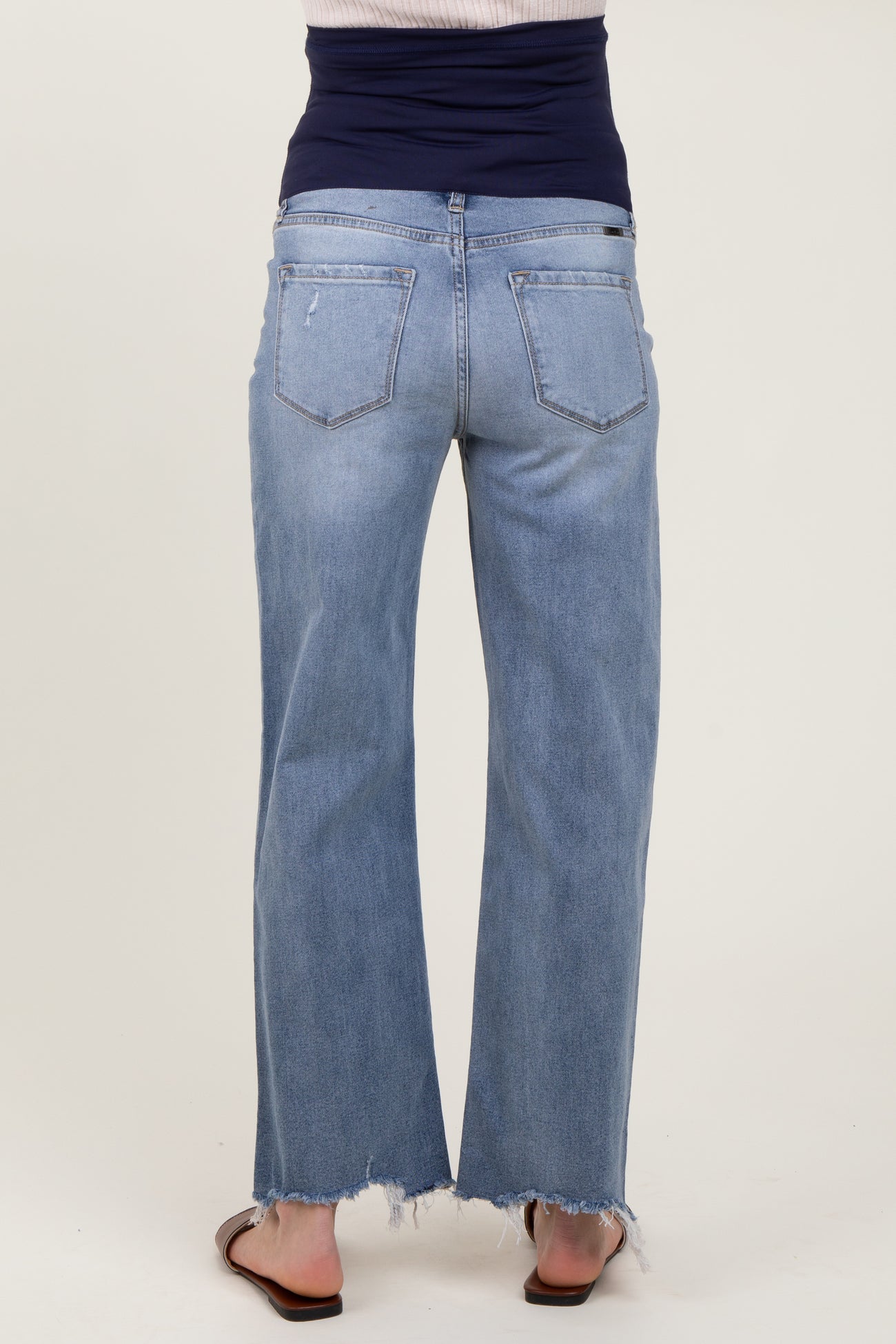 maternity wear light blue wide-leg jeans with a frayed hem, shown from the back on a model