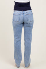 woman wearing light blue maternity jeans viewed from the back, featuring a relaxed fit and slight distressing