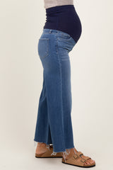 woman wearing a pair of light wash maternity flared jeans with a high waistband and a visible baby bump