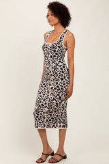 woman wearing a leopard print midi dress with adjustable straps and a fitted silhouette