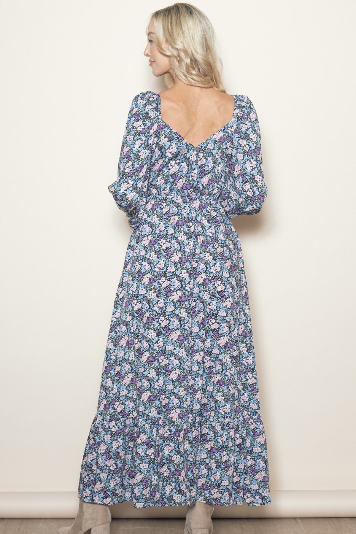 woman wearing a floral long sleeve maxi dress with a v-back and tiered skirt