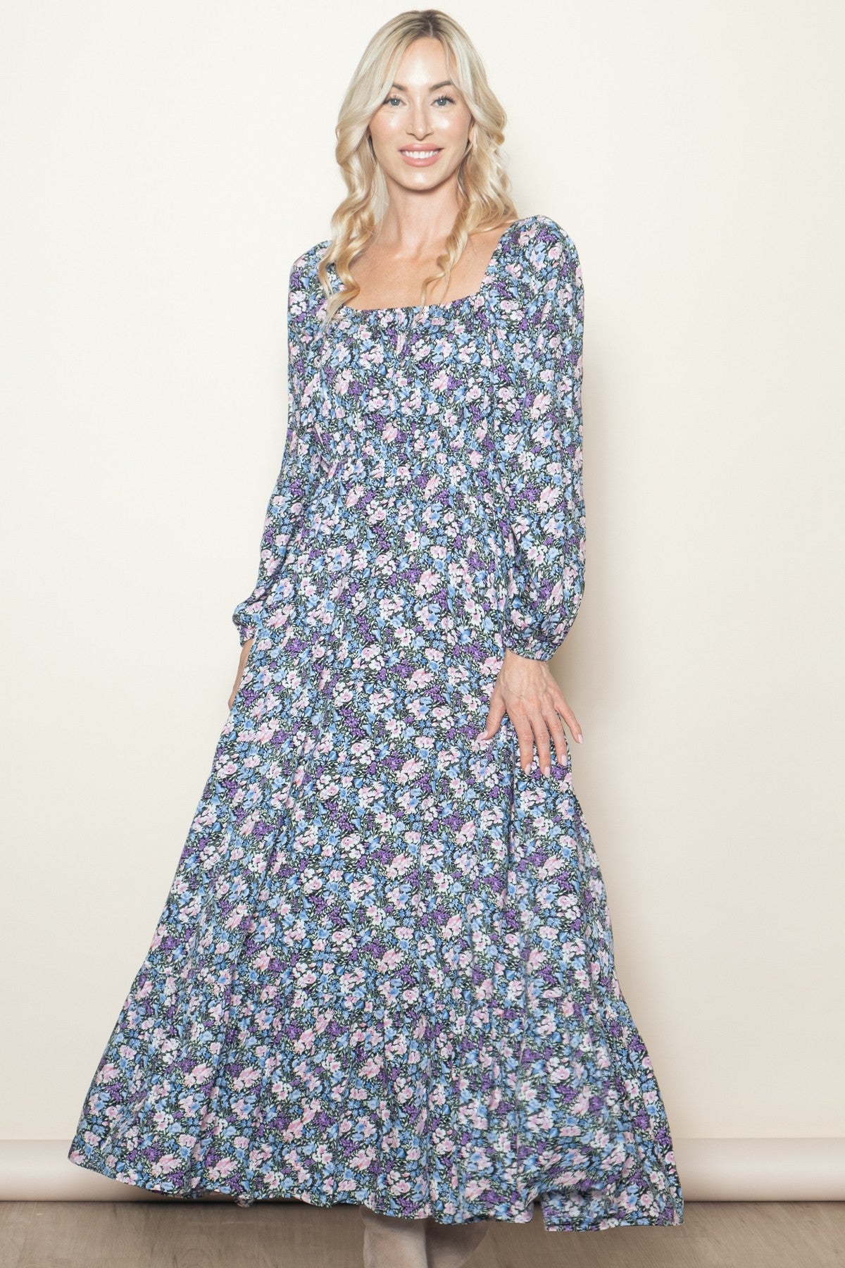 woman wearing a long sleeve floral maxi dress with a square neckline and puffed sleeves