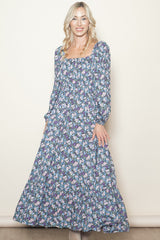 woman wearing a long sleeve floral maxi dress with a square neckline and puffed sleeves