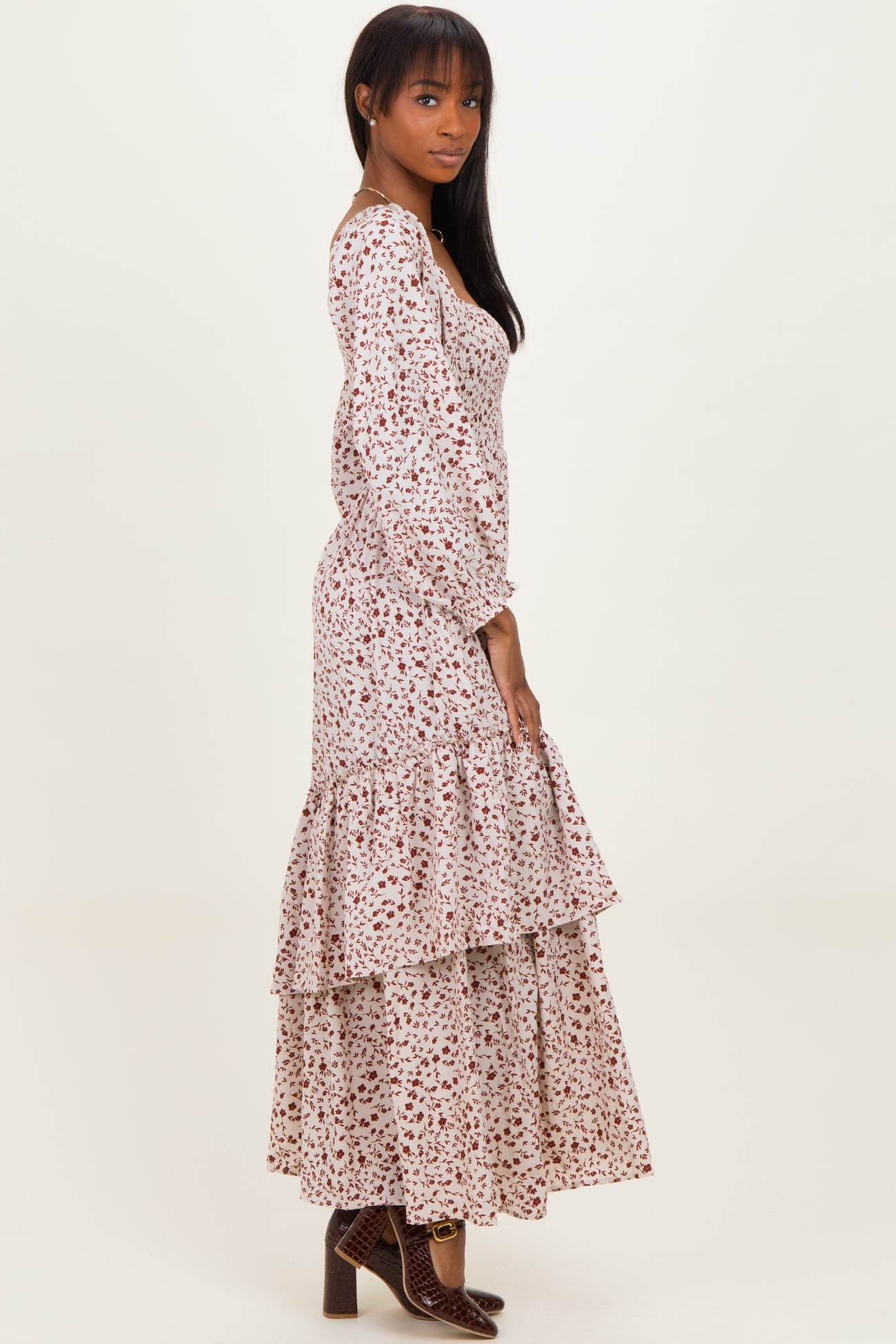 woman wearing a floral print long sleeve maxi dress with tiered ruffles and a fitted bodice