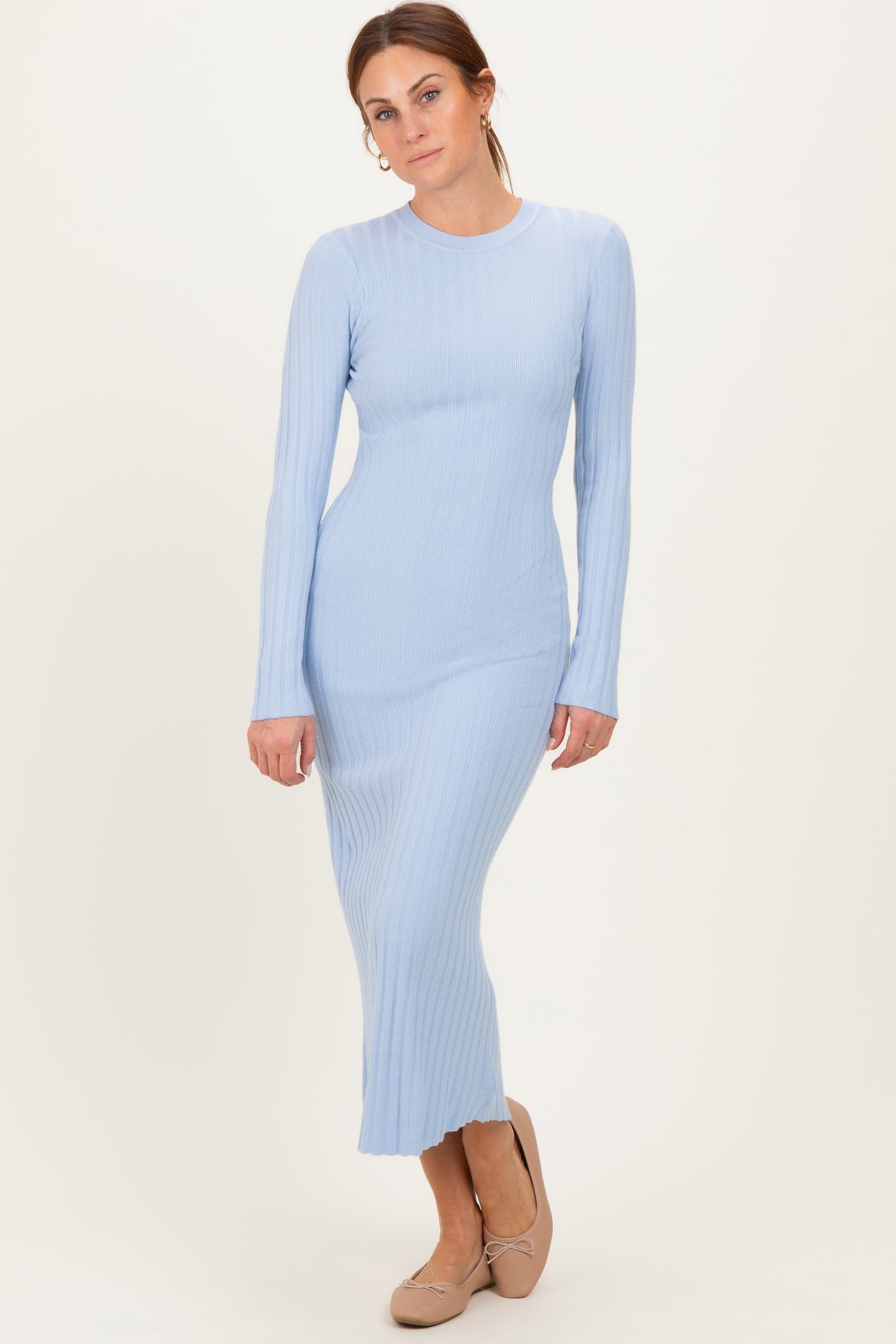 woman wearing a light blue ribbed long sleeve dress that falls to the ankles