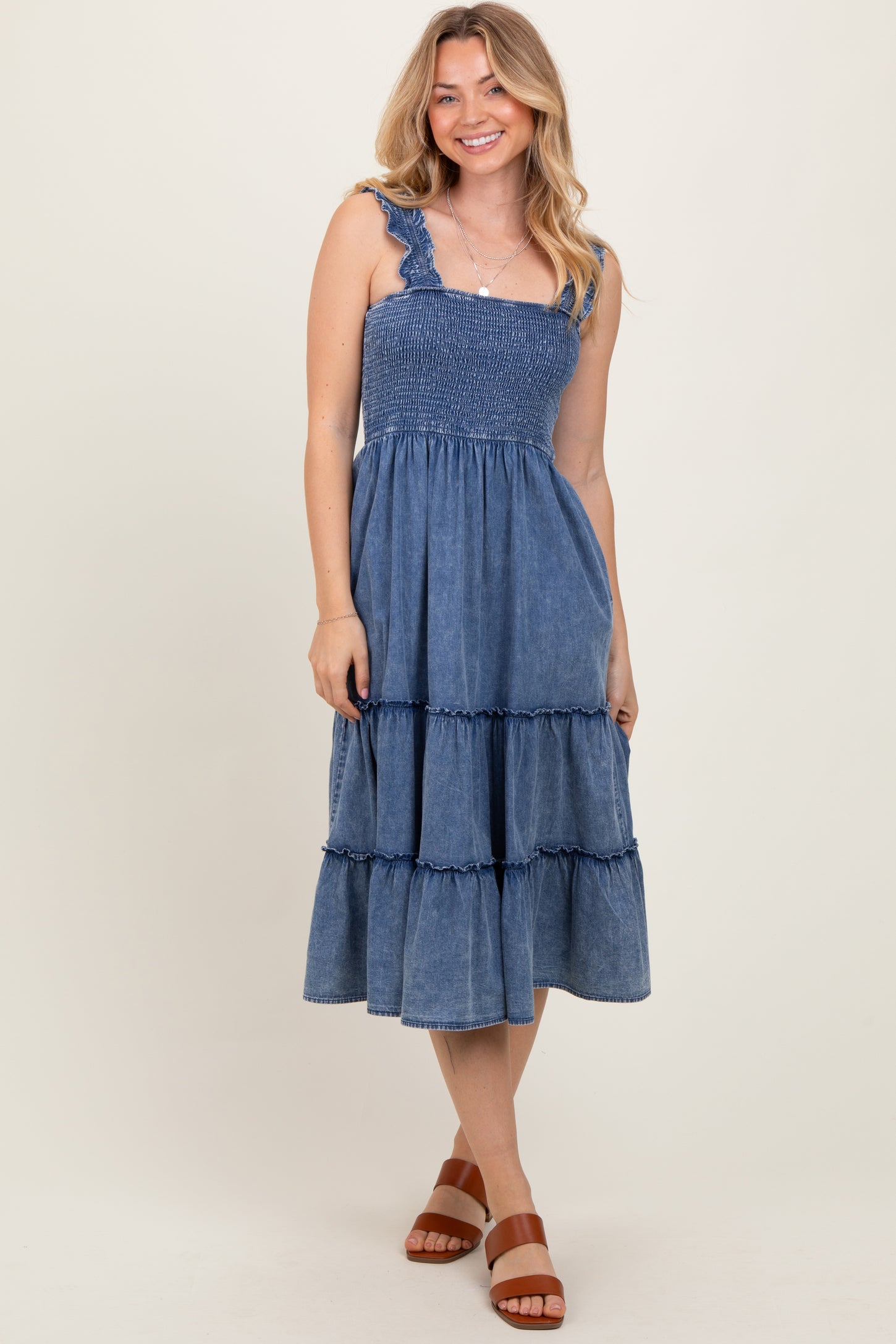 woman wearing a denim blue tiered maxi dress with ruffled straps and a smocked bodice