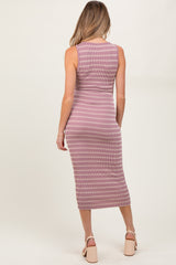 woman wearing a pink and white striped maternity midi dress, showing a sleek silhouette from the back