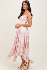 woman wearing a pink floral midi dress with a flowy hem and spaghetti straps, styled with a headband and heels