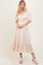 woman wearing a light peach puff sleeve maxi dress with a smocked bodice and ruffled hem