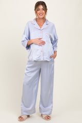 woman wearing a light purple satin maternity pajama set with a baby bump visible, featuring a pocket and pink piping details