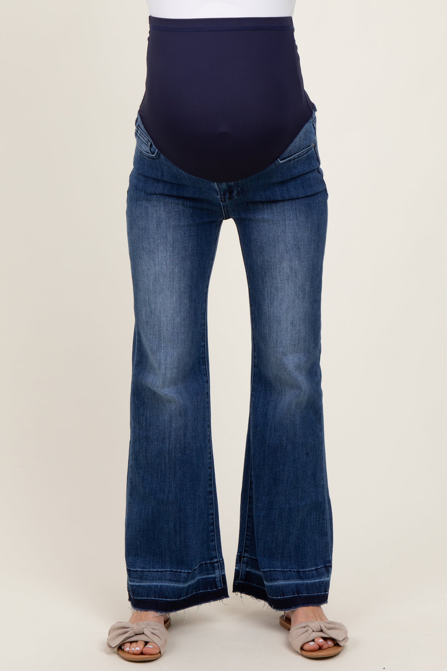 woman wearing dark blue flared maternity jeans with a panel for a baby bump