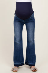 woman wearing dark blue flared maternity jeans with a panel for a baby bump
