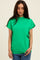 woman wearing a bright green short sleeve top with a high neckline and relaxed fit