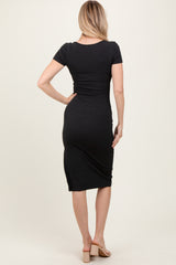 woman wearing a black fitted midi dress with short sleeves, view from the back