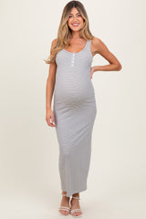 woman wearing a gray and white striped maternity maxi dress with buttons, highlighting her baby bump