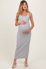 woman wearing a gray and white striped maternity maxi dress and cradling her baby bump