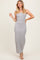 woman wearing a stripped gray maxi dress with a button-down front and spaghetti straps