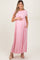 woman wearing a light pink short sleeve maternity maxi dress and holding her baby bump