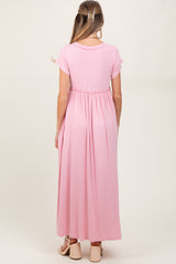 woman wearing a pink maternity maxi dress with short sleeves and an empire waist, showing a baby bump