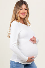 woman wearing a ribbed white maternity top and showcasing her baby bump
