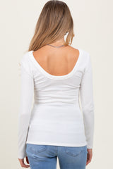 woman wearing a white long sleeve maternity top with a low back and ribbed texture