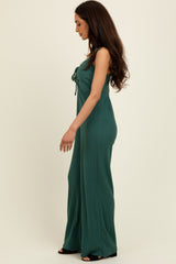 woman wearing a dark green ribbed jumpsuit with a tie detail at the front and wide legs