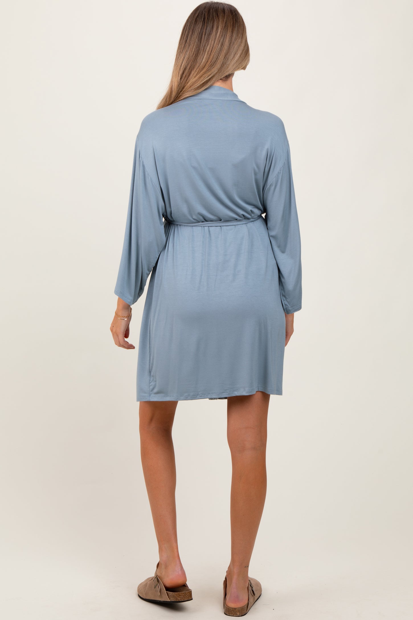 woman wearing a light blue maternity robe with long sleeves and a tie waist from the back