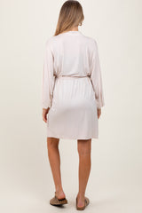woman wearing a light pink maternity robe with a tie waist detail, shown from the back