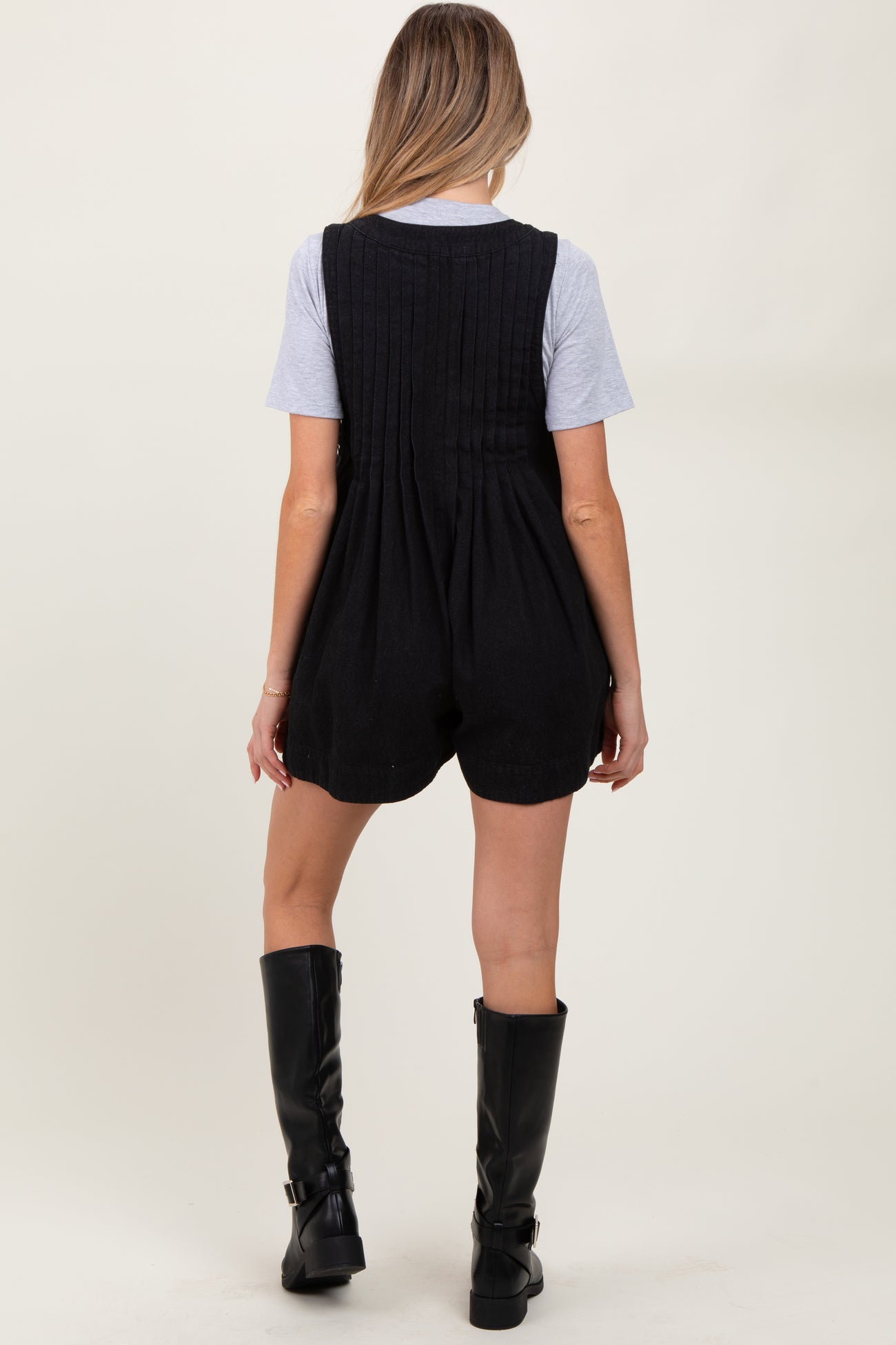 woman wearing a black maternity romper with a textured back and a gray t-shirt underneath