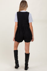 woman wearing a black maternity romper with a textured back and a gray t-shirt underneath