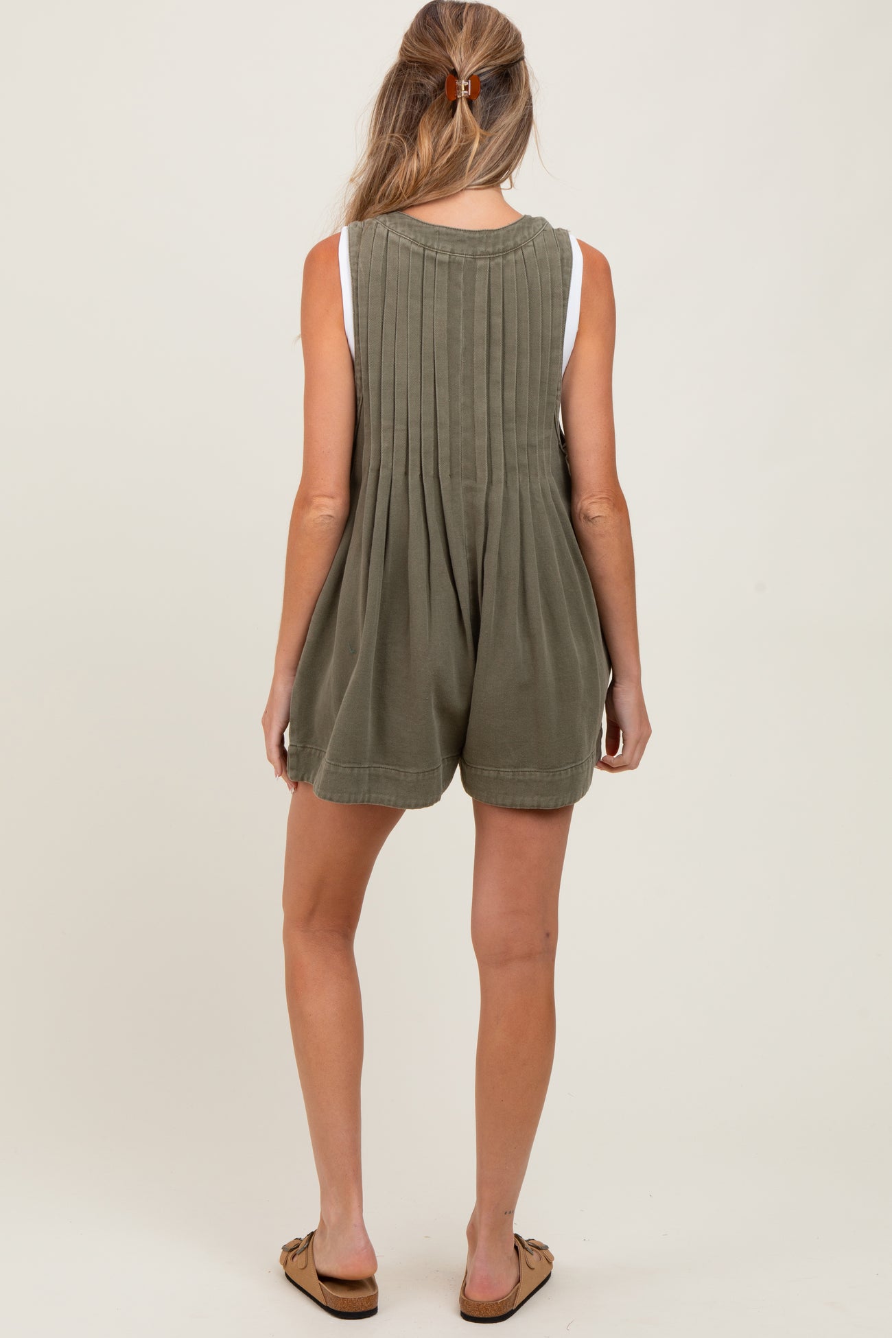 woman wearing a green maternity romper with pleated back and casual shorts style